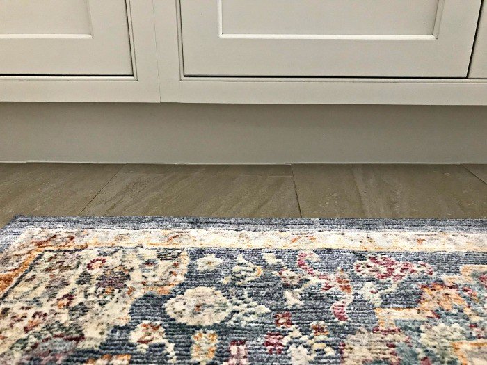 Fix that small gap between cabinets and floor in your kitchen, bath, and laundry with this quick and easy DIY update. For less than $10 and in 30 minutes you can caulk that gap and block out all of the spills, dirt, and crumbs that get caught in the crack.