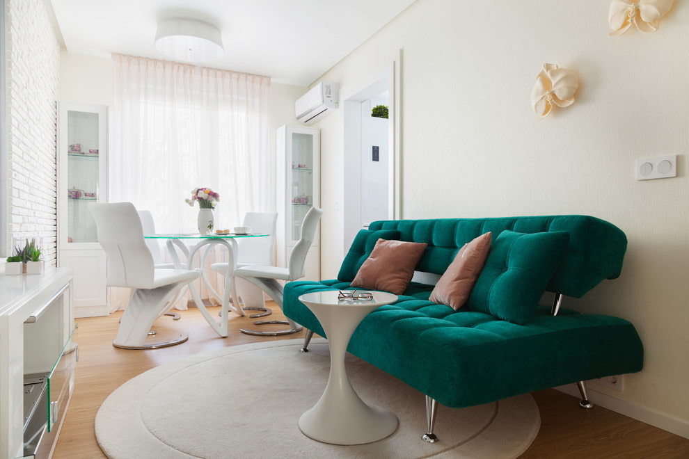 Зеленый диван в светлой столовой-гостиной