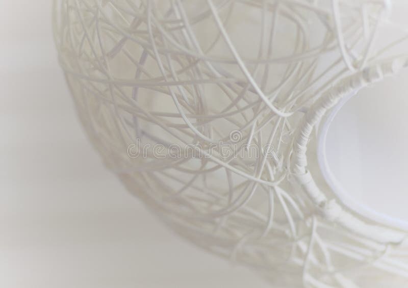 Abstract wallpaper in white color with element of wicker ceiling lamp. Abstract wallpaper in white color with element of globe shaped wicker ceiling lamp royalty free stock photo