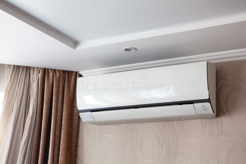 Air conditioning on the wall inside the room in apartment, switched off. Interior in calm beige tones.  royalty free stock photos