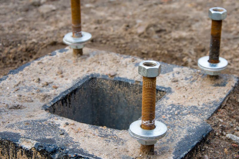 Anchor bolts are concreted into the support, fastening to the nut on the thread. Anchor bolts are concreted into the support, fastening to the nut on the thread stock images