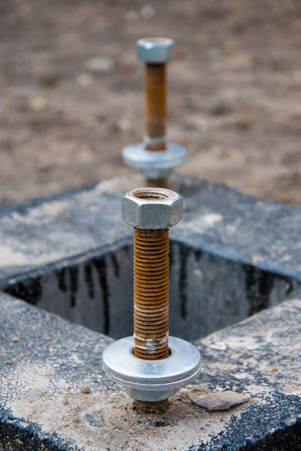 Anchor bolts are concreted into the support, fastening to the nut on the thread. Anchor bolts are concreted into the support, fastening to the nut on the thread stock photo