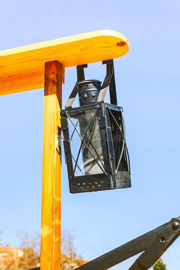 An ancient iron lantern, suspended on a wooden structure, was used on fire trucks in the old days. Close-up stock images