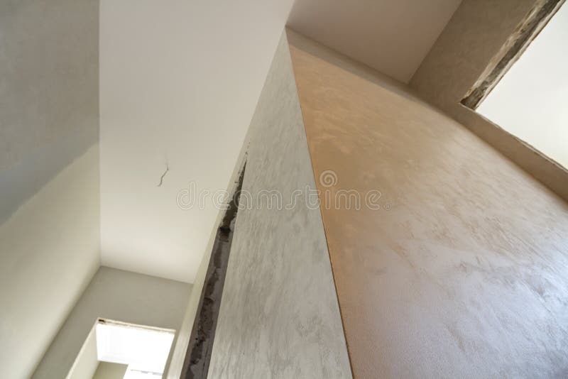 Angled view of new unfinished apartment under reconstruction. White ceiling, plastered walls, doors openings. Construction and. Reconstruction concept royalty free stock image