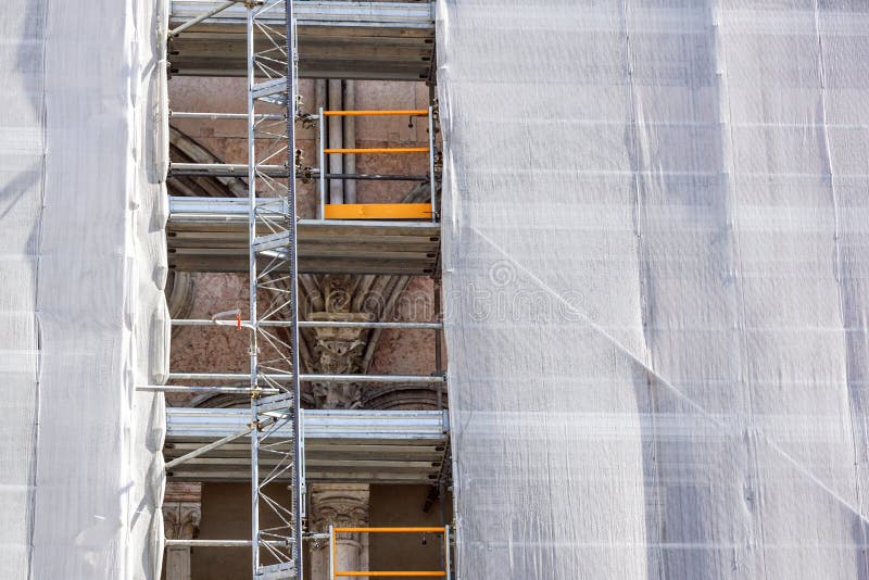 Apartment building exterior under renovation with scaffolding and green netting stock photography