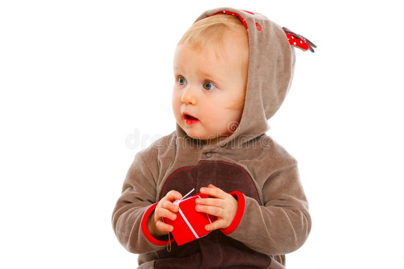 Baby with Christmas gift box looking in corner stock photo