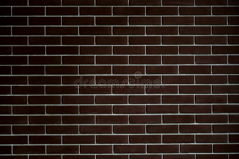 Background of a brick dark wall, tile texture with a smooth pattern. stock image