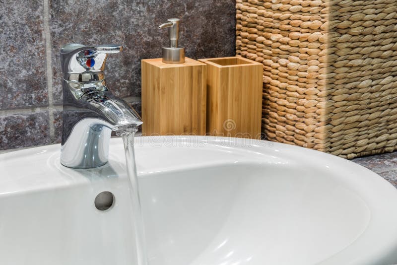 Bathroom sink area design, in bathroom with dark tiles. Mirror and decorations stock image