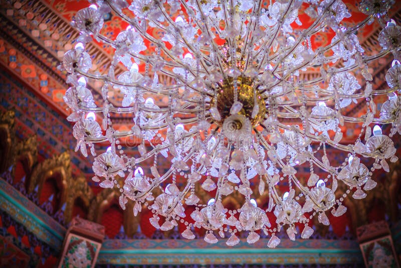 Beautiful chandelier lamp is hanging on the decorated ceiling in. The Buddhist church, Thailand. Colorful pattern of ceiling with decorative chandelier lamp royalty free stock photos