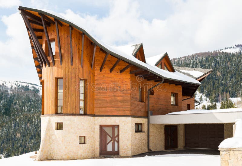 Beautiful modern wooden house covered in snow, ski resort Donovaly. Slovakia royalty free stock photo