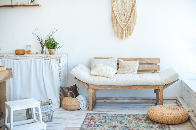 Beautiful spring photo of kitchen interior in light textured colors. Kitchen, living room with beige couch sofa, large cactus and. Woven macrame on the wall stock photography