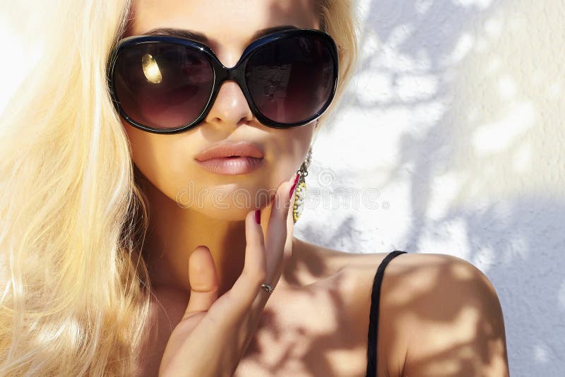 Beautiful woman in sunglasses.beauty blond girl in near the wall. Summer royalty free stock images