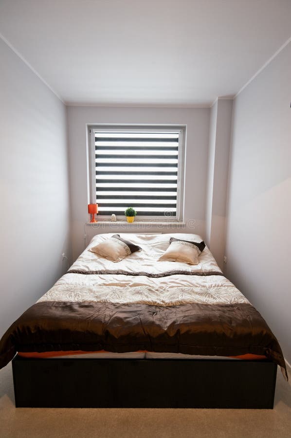Bedroom. A sparse composition of a small bedroom with double bed and window with blinds royalty free stock photography