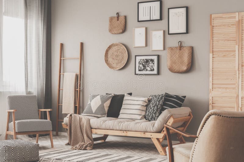 Beige scandinavian settee with patterned pillows in stylish living room interior. Beige scandinavian settee with patterned pillows in stylish living interior royalty free stock images
