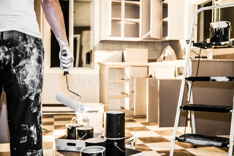 Big Painting Job !. Mess of All kind of Painting Equipment in the Kitchen and Discouraged Man royalty free stock photo