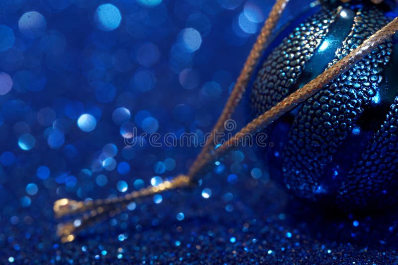 Blue ball is a classic Christmas decoration on a blue background. Free space for an inscription. Holiday trends 2020. Imitation of. Night snowfall. Greeting stock image