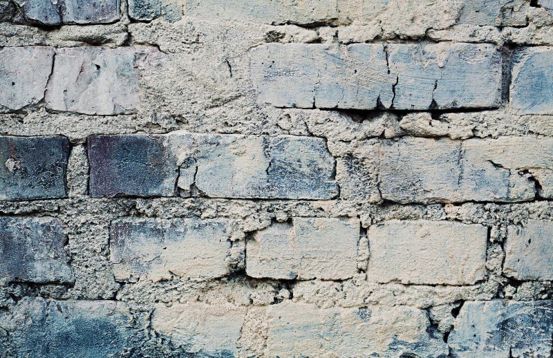 Blue brick wall with cracks and scuffs, urban loft background. Aged blue brick wall with cracks and scuffs, urban loft background royalty free stock images