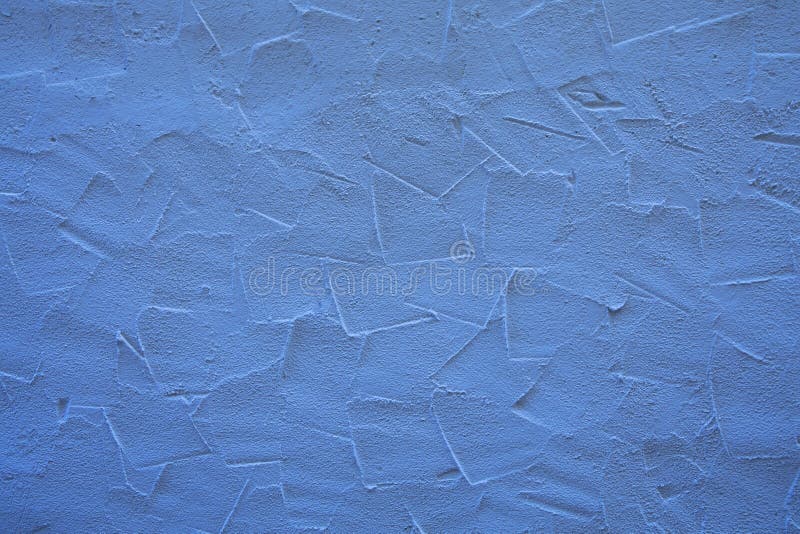 Blue wall of embossed decorative plaster. Rough blue wall surface of decorative embossed painted lime plaster background texture, close up royalty free stock photos