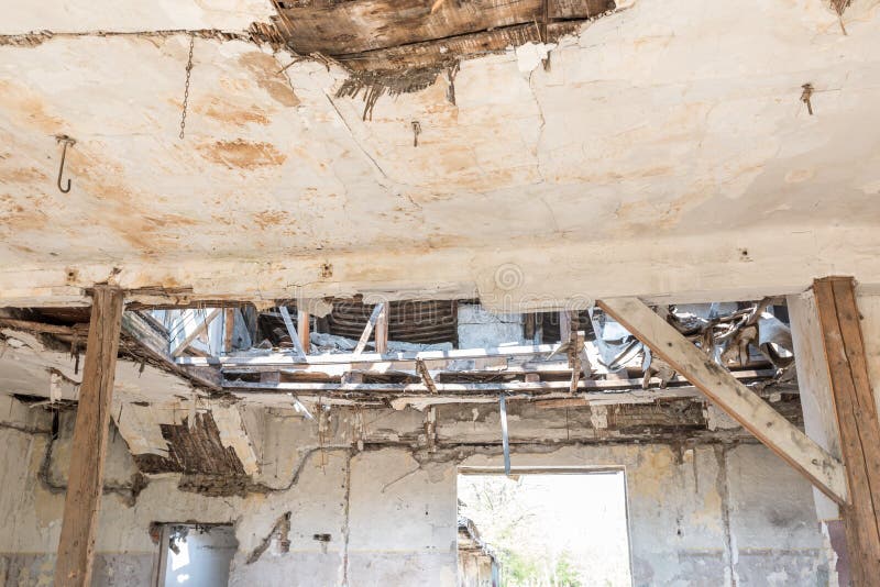 Broken damaged and collapsed ceiling and roof of old house abandoned after aftermath disaster and heavy rain leakage.  stock photo