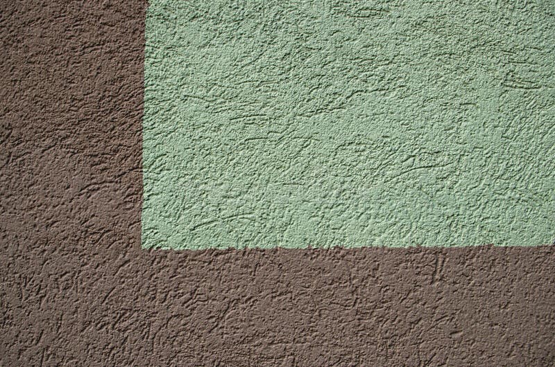 Brown and green fragment of the wall of the building in the form of a right angle on the left with decorative plaster stock photography
