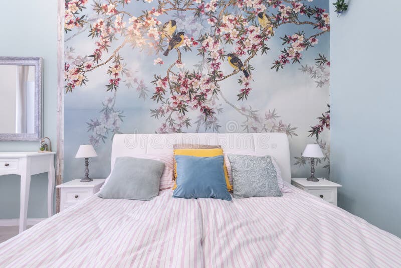 Budapest, Hungary - June 10, 2019: Detail shot of bedroom with modern stylish spring birds theme wallpaper, colorful pillows and. Budapest, Hungary - June 10 stock photo