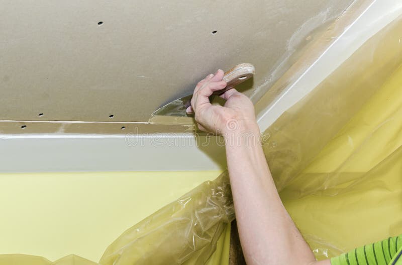 Puttying drywall seams. Builder embeds the joints drywall putty, close-up royalty free stock photography