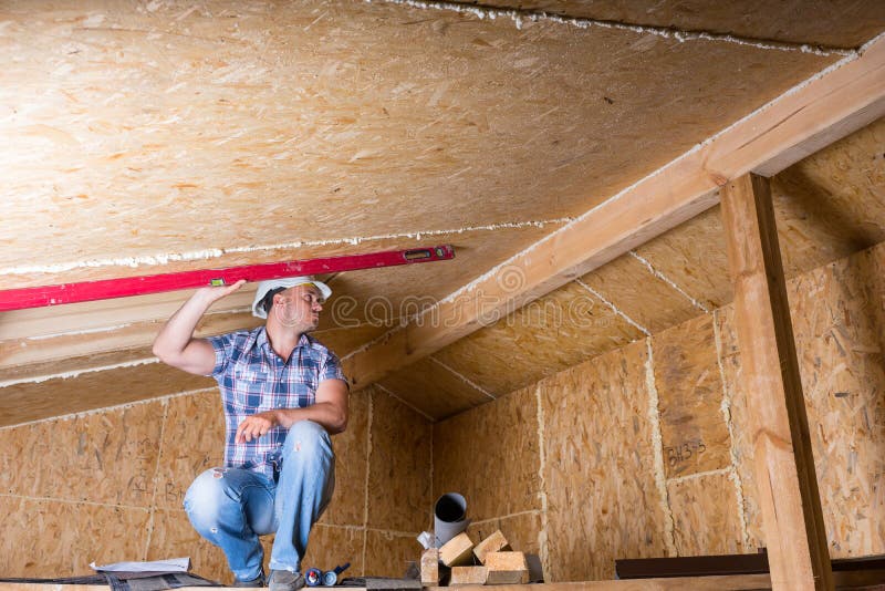 Builder Using Level on Ceiling in Unfinished Home royalty free stock images