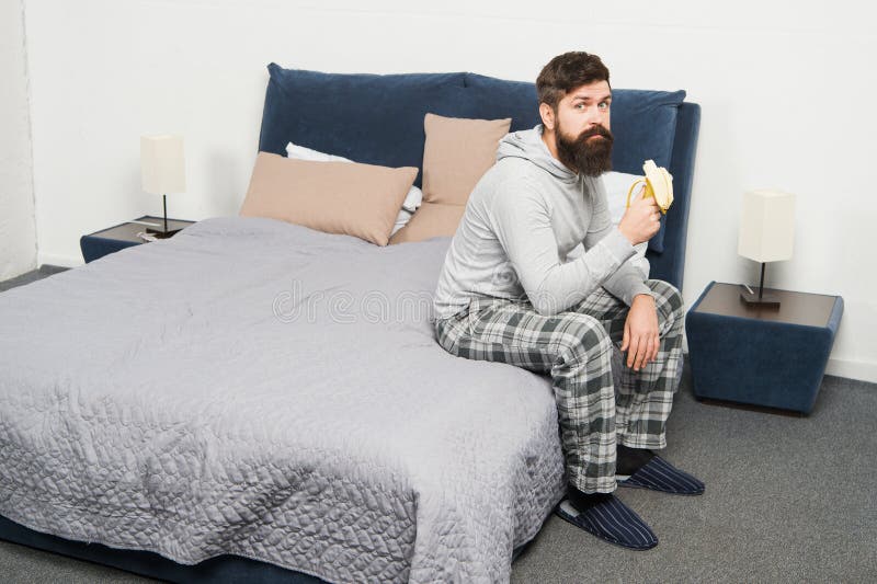 Calorie snack. Man bearded hipster sleepy face pajamas waking up bedroom interior. Healthy lifestyle. Rest and relax royalty free stock images