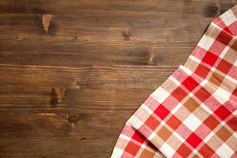 Checkered napkin at right bottom corner of wooden background royalty free stock images