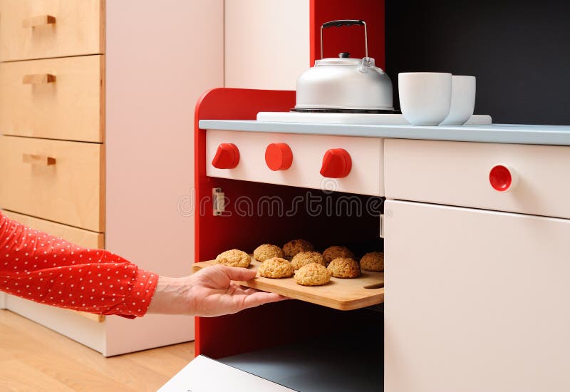 Children play in kitchen. Baking homemade cookies in toy oven. Closeup stock image