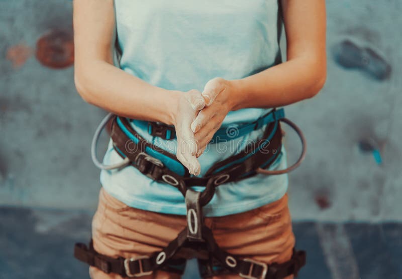 Climber woman coating her hands in powder stock photo