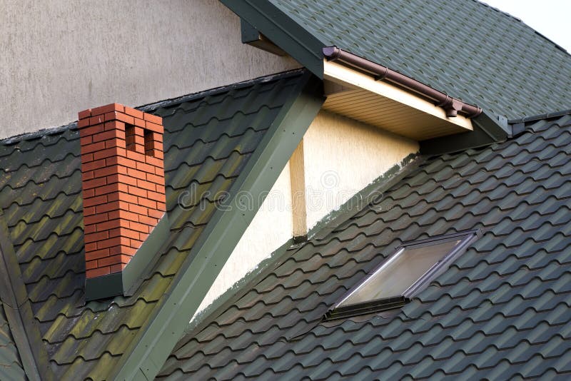 Close-up detail of new small attic plastic window installed in d. Ark green shingled house roof background. Professionally done building and construction work royalty free stock image