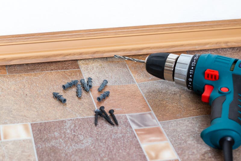 Furniture assembly parts and tools for self assembly furniture, on the floor.Installation of plastic floor plinth. Interior detail stock image