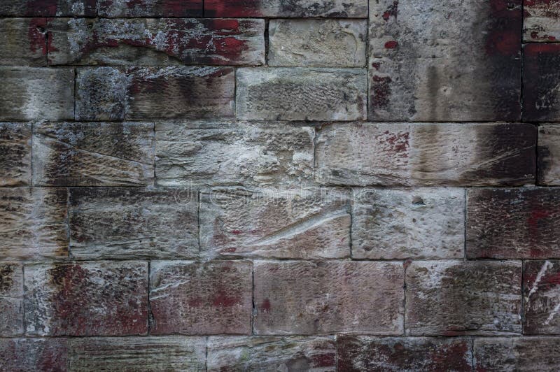 Close-up of an old weathered sandstone wall of different sized s. Tones and texture with efflorescence and red, white and black spots of color stock images