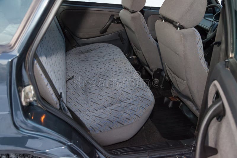 Close-up on rear seats with velours fabric upholstery in the interior of an old russian car in gray after dry cleaning. Auto. Service industry stock photo