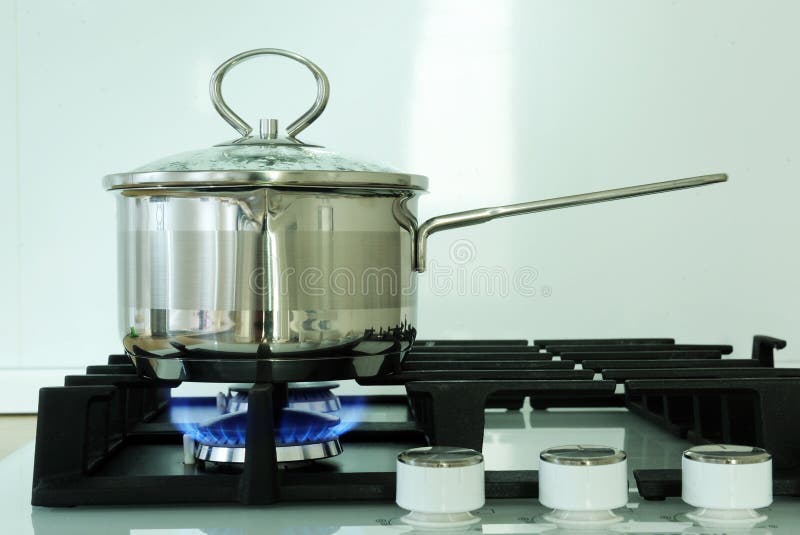 Pot on the gas stove in kitchen. Close-up of stainless steel cooking pot on gas stove in royalty free stock images