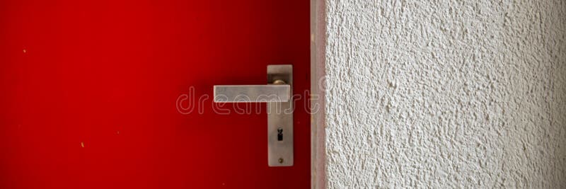 Closed metal door with a handle and plastered wall stock photo