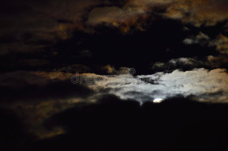 Clouds and moon in the night sky. The perfect picture requieres to find the perfect moment by setting the camera configuration and hopping that the wind will stock images