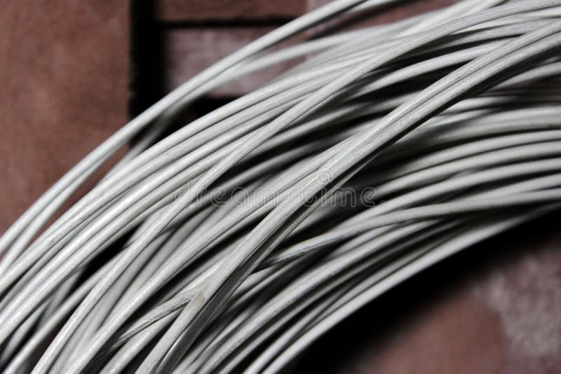 A coil of fechral thick refractory wire hangs in a warehouse of goods for ceramists. Frame of coiled nichrome wire for. Heating element stock image