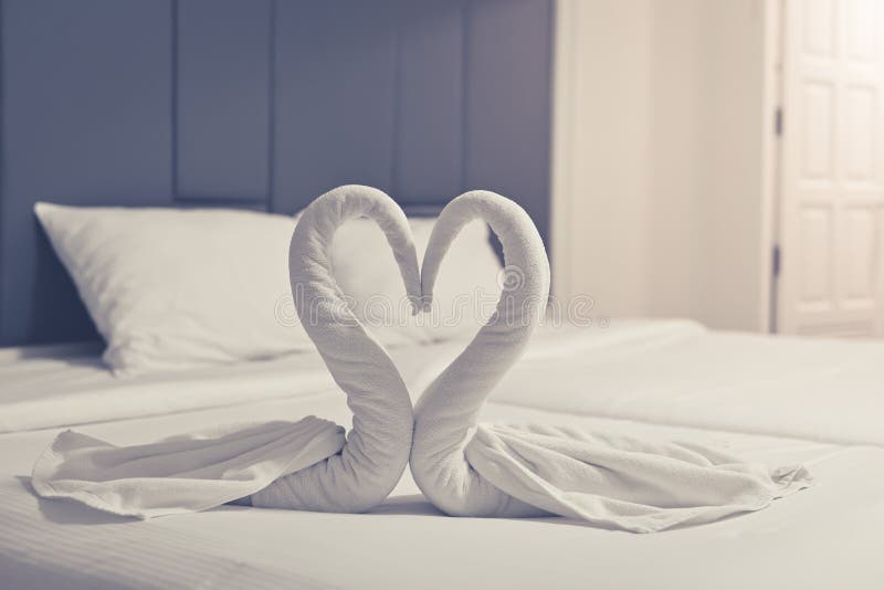 Comfortable bedroom,Towels arranged as swans heart in the bedroom for romance decorative trip stock images