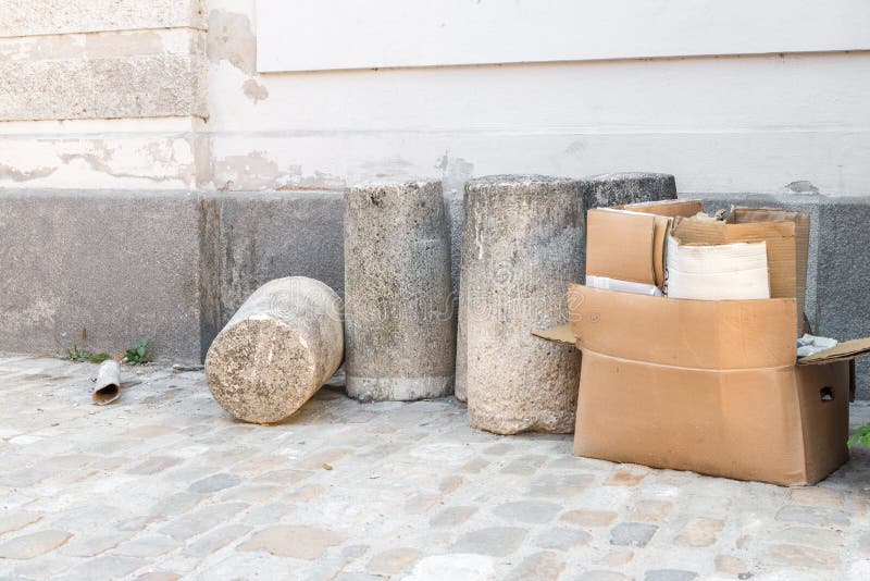 Concrete bollard and cardboard box on a street corner.  royalty free stock photo