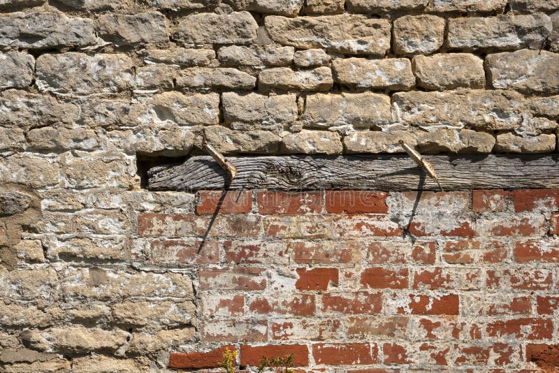 Construction background - an old brick wall needs repairs. An old weathered brick and stone wall needs repairs. Construction full frame texture background stock photography