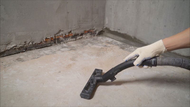 Construction cleaning service sleeve anchor bolt . dust removal with vacuum cleaner. Worker vacuuming concrete floor. Worker vacuuming concrete floor royalty free stock photos