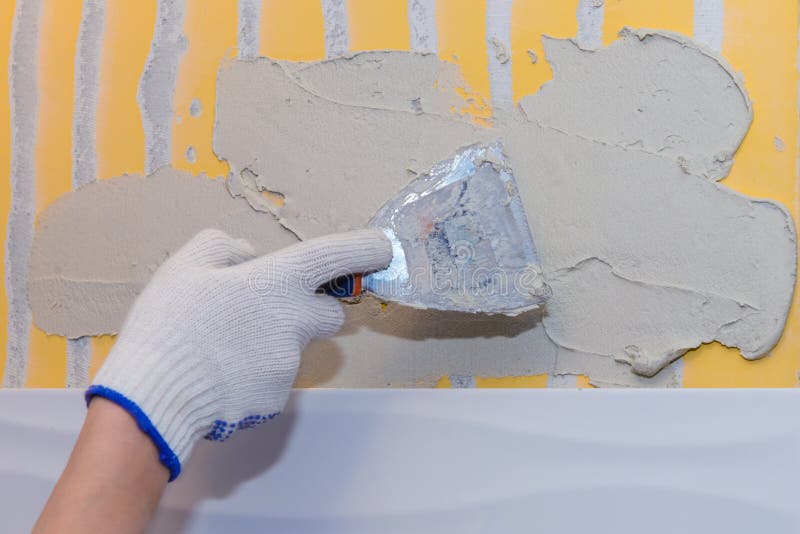 Construction work laying tile on the wall stock image