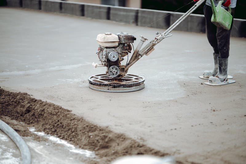 Construction worker finishing concrete screed with power trowel machine, helicopter concrete screed  finishing and smoothing. Worker finishing concrete screed royalty free stock image