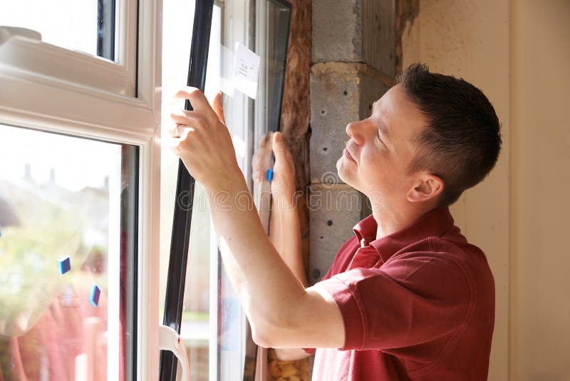 Construction Worker Installing New Windows In House stock images