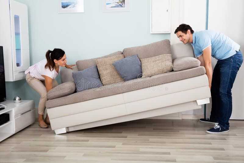 Couple Placing Sofa In Living Room stock image