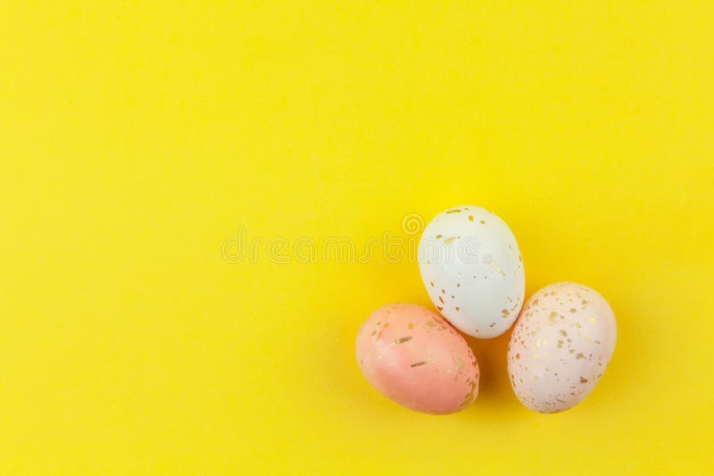 Creatively dyed decorative eggs in pastel colors decorated with gold leaf on yellow background, copy space. Happy Easter do it royalty free stock photography