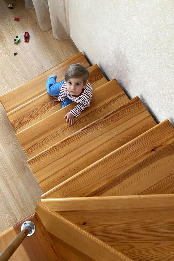 Cute young boy sitting on stairs on the second floor royalty free stock photo