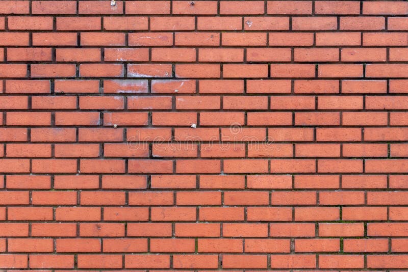 Dark Red Brick Wall. Texture of lightly weathered and stained dark red brick wall with dark grouting and some screws stock photos